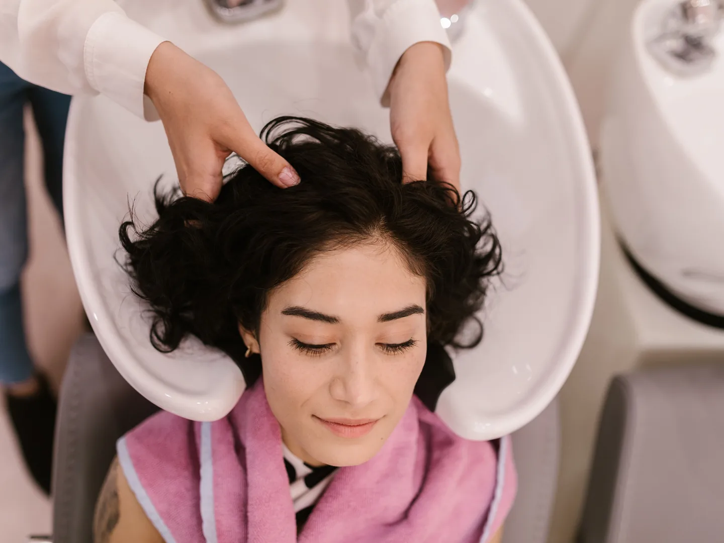 A client reclining during a scalp and hair treatment